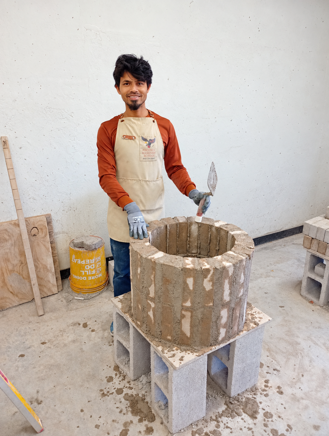Phoenix Masonry School student with his cylindrical brick chimney practice project